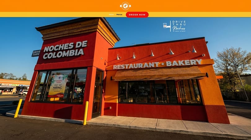 Exterior of Noches de Colombia restaurant and bakery with a drive-thru, featuring orange and red walls.